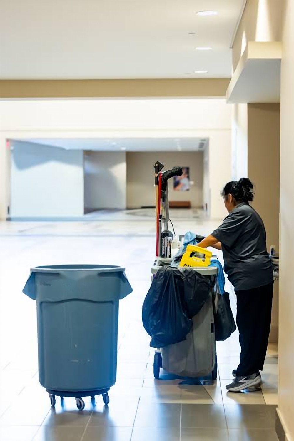 Cleaner with a trolley in a clean corridor
